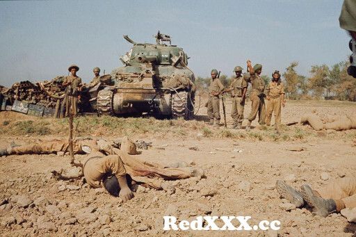 View Full Screen: view of indian soldiers standing either side of a sherman tank observing corpses of dead soldiers after a battle in a di.jpg